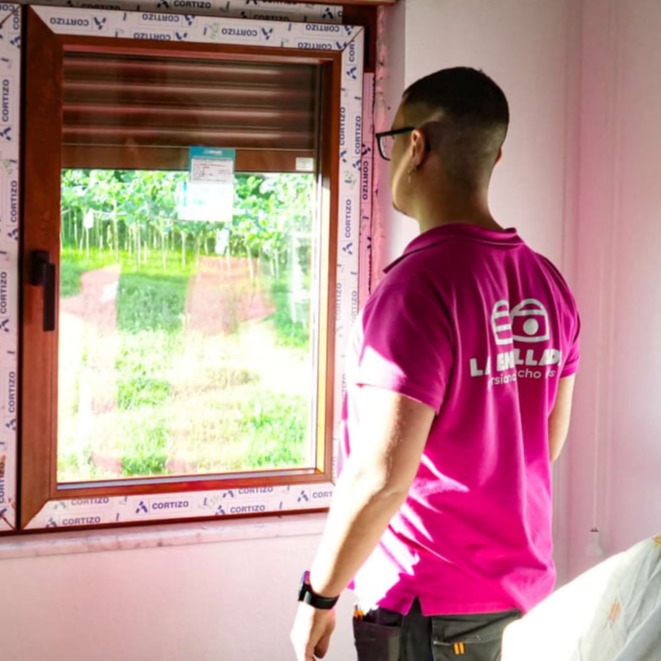 persianas la enrollada coruna tecnico instalando una ventana